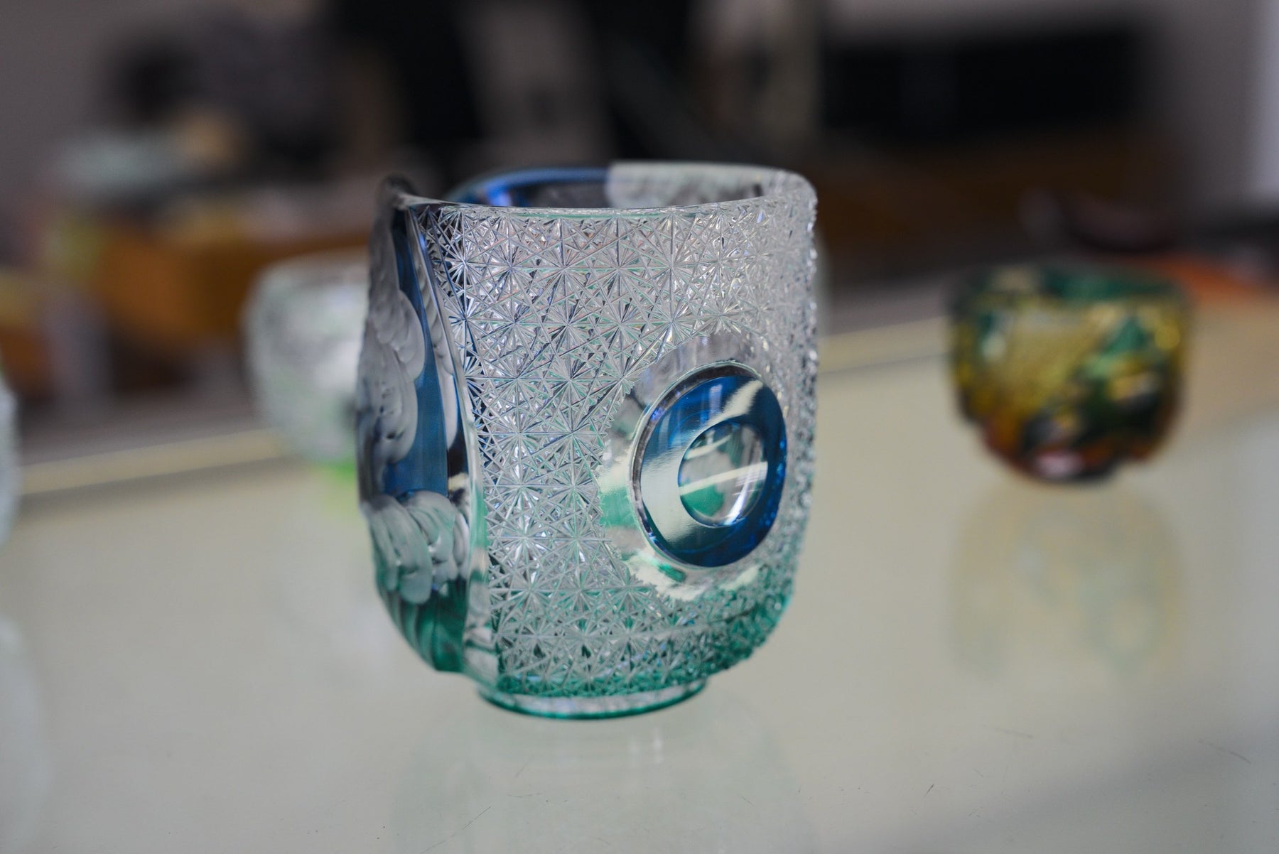 Cut-glass cup with dense faceted pattern and round porthole cut, Haku Glass showroom