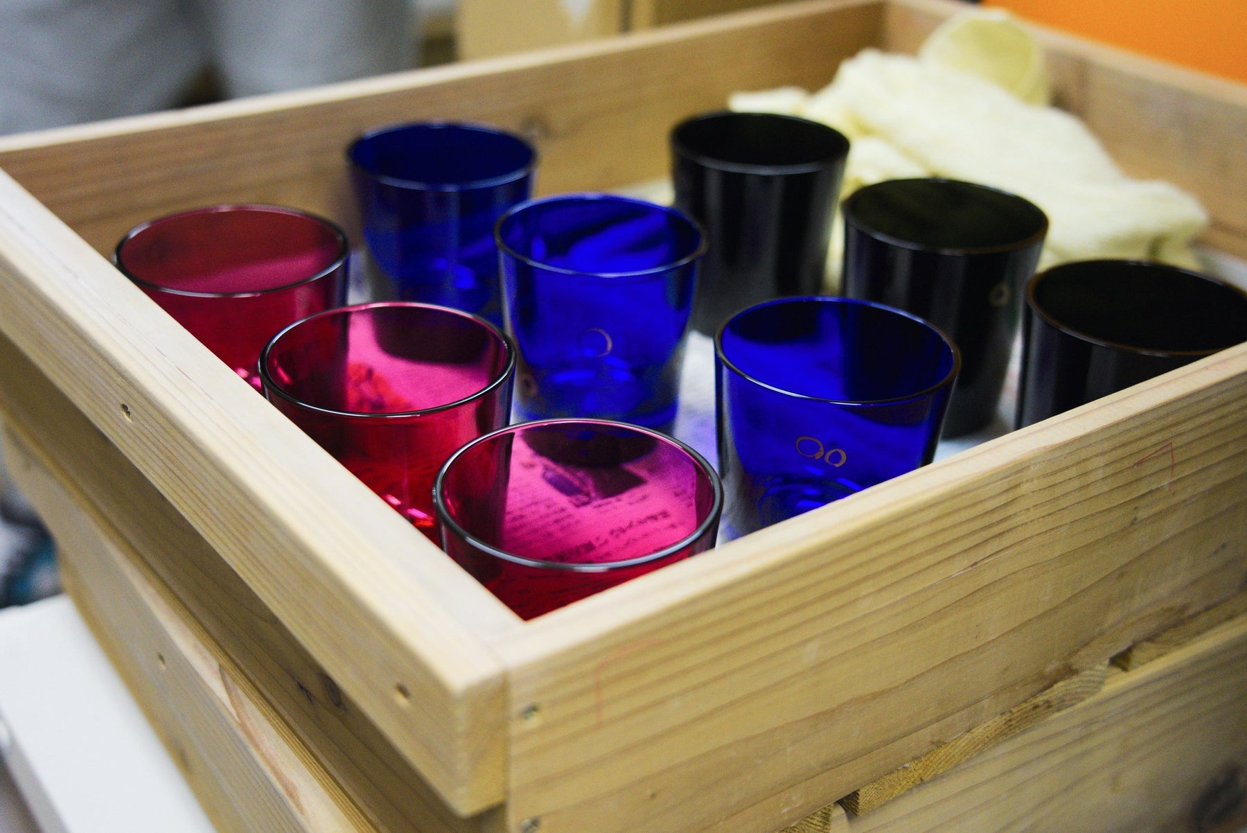Blue, red and black cut-glass tumblers in a wooden crate at Rinzen, Tokyo, 8 April 2022