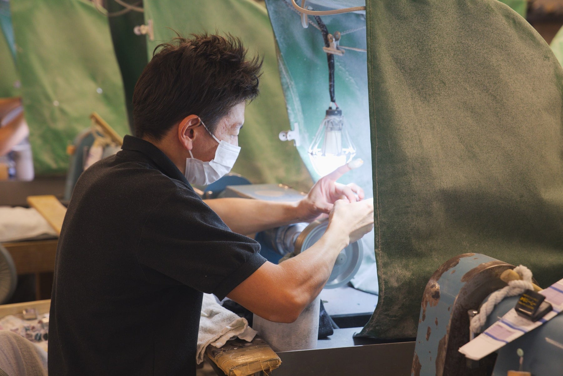 Craftsman cutting glass against a spinning wheel