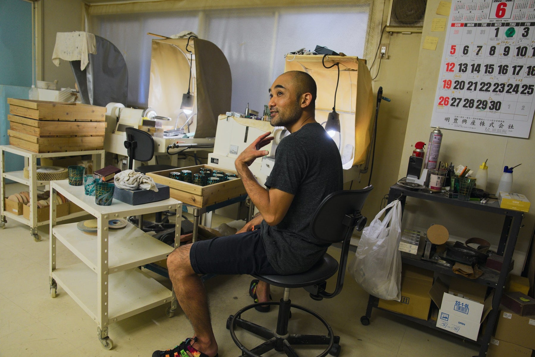 Craftsman at his workbench with a June wall calendar behind him