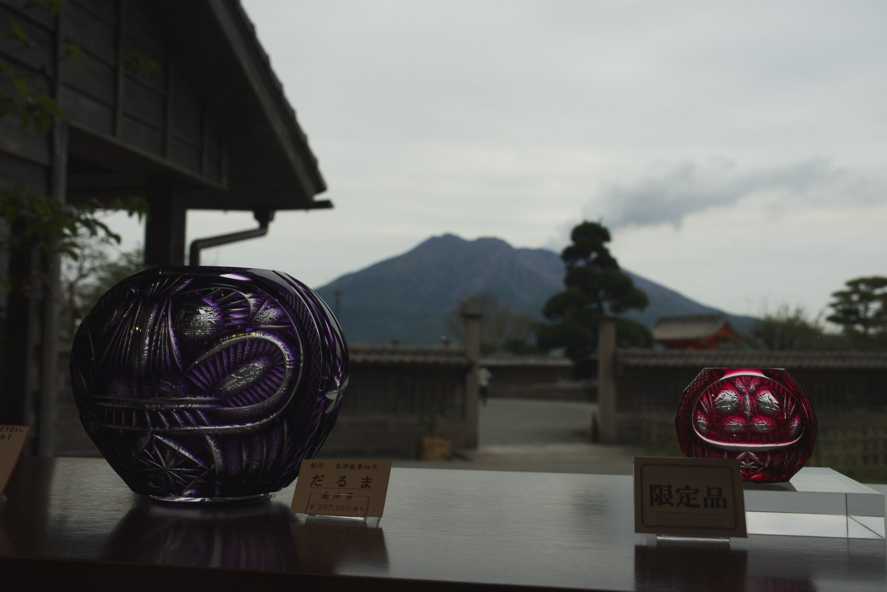 Finished Satsuma Kiriko pieces on display with Sakurajima volcano behind