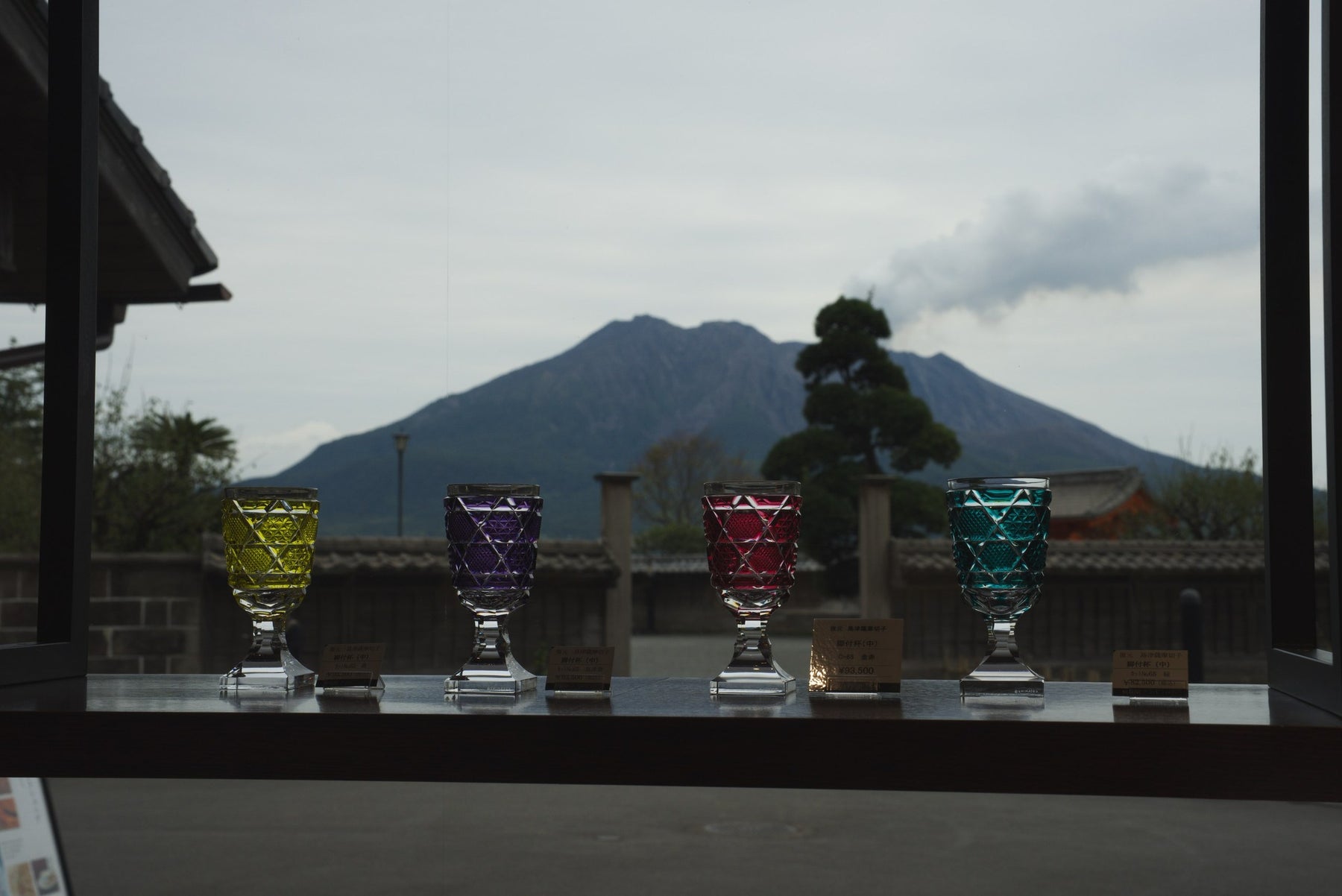 Four Satsuma Kiriko goblets in yellow, purple, red and teal on display